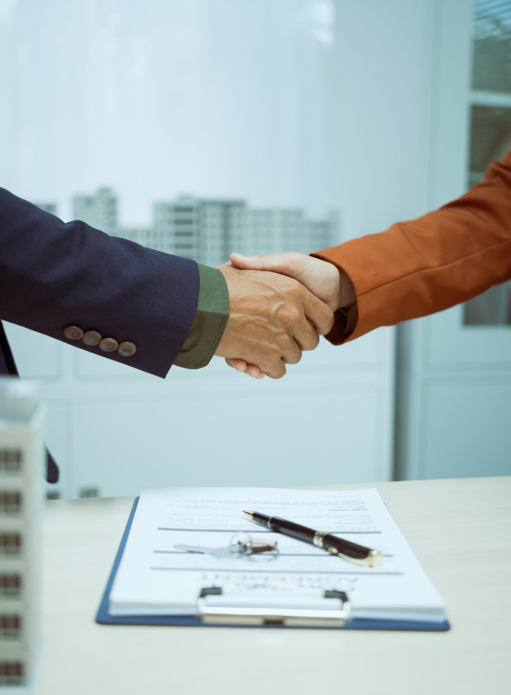 A businessman shakes hands with customer in the sales office after agreeing sign contract to buy